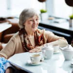 Senior woman sitting in cafe with friends