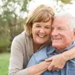 Older couple smiling and embracing.