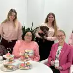 Six members of the Ashridge Home Care team and the office dog 'Snoop' all wearing pink in support of breast cancer awareness month.