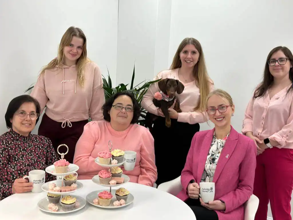 Six members of the Ashridge Home Care team and the office dog 'Snoop' all wearing pink in support of breast cancer awareness month.