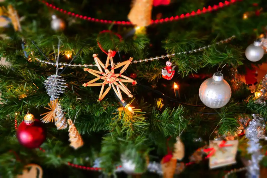 Close up of a decorated Christmas tree with baubles and fairy lights.