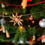 Close up of a decorated Christmas tree with baubles and fairy lights.