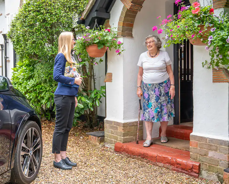 Ashridge Home Care's client services manager greeting a new client at their door, ahead of starting their personalised care service.