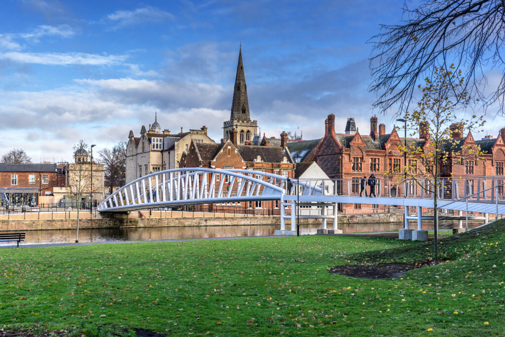 Bridge over the Great Ouse River, with buildings and church spire along the riverbank, Bedford, UK