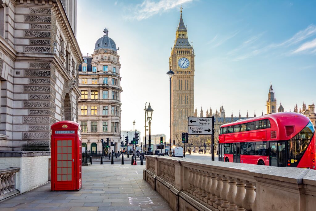 Red telephone box and double-decker bus on Parliament square and Big Ben tower, London, UK