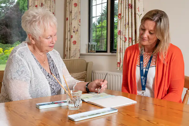 Client with Ashridge Home Care carer painting watercolours