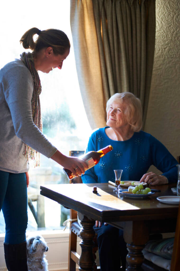 Care and independence-carer serving elderly lady a drink