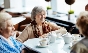 Senior woman sitting in cafe with friends