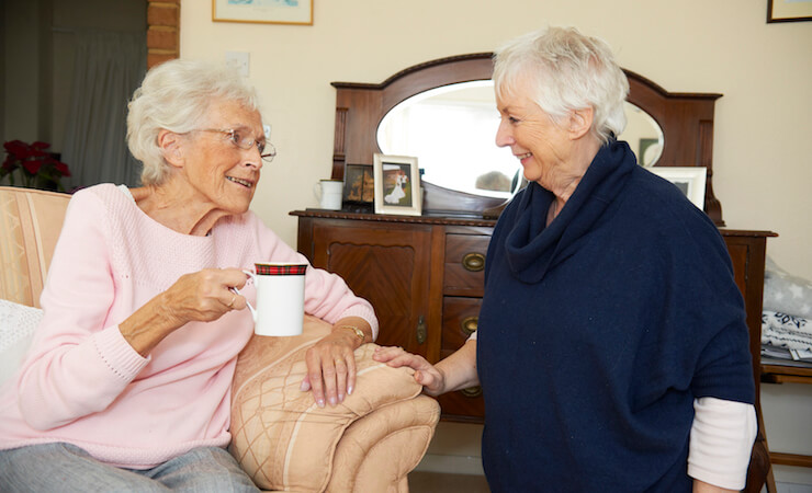 Parkinsons care-elderly lady having tea with friend
